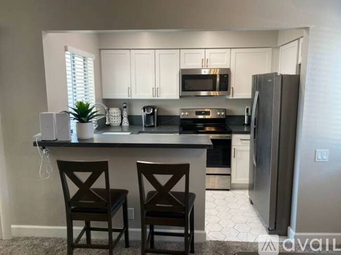 A kitchen with a black countertop and white cabinets.