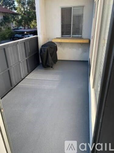A patio with a bench and a grey wall.