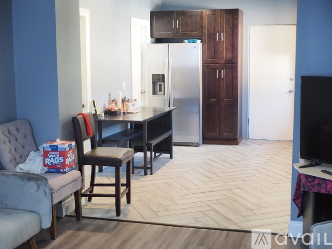 A kitchen area with a fridge, microwave, and a TV.