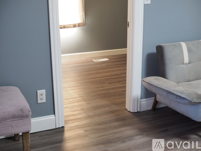 A room with a light-colored couch and a wooden floor.
