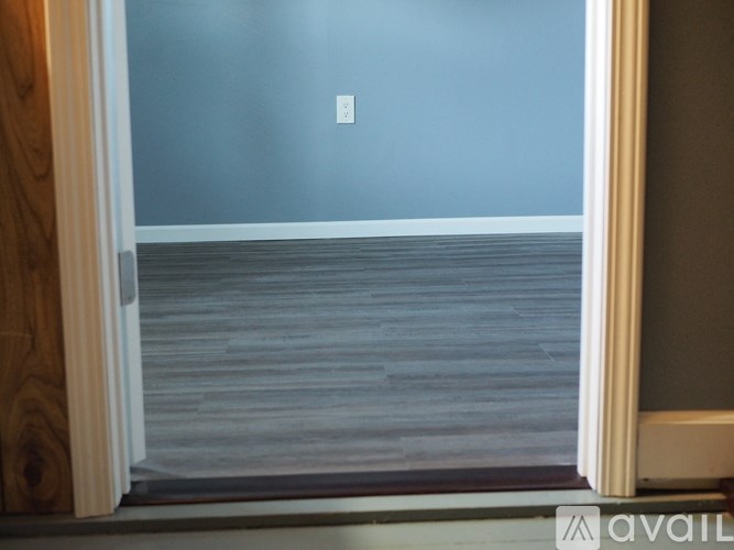 A room with a wooden floor and a white door.