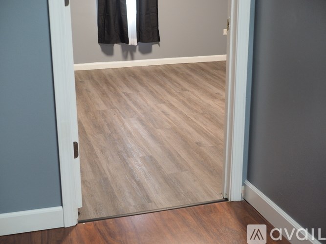 A room with a wooden floor and a grey wall.