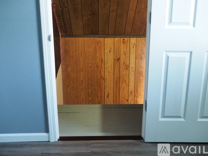 A room with a wooden ceiling and a white door.