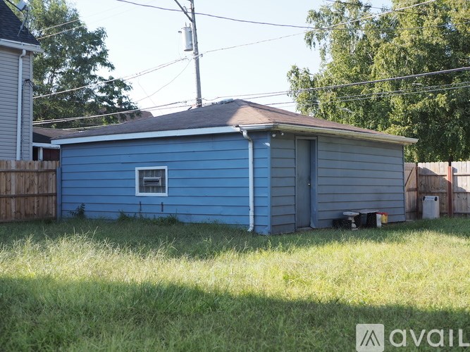 A blue house with a brown roof and a window.
