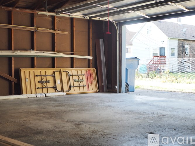 A garage with a white door and a brown shelf.