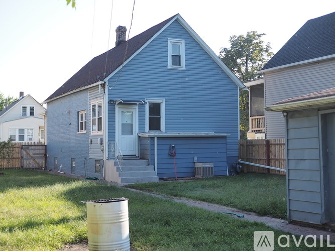 A blue house with a white door and a red fire hydrant in front.