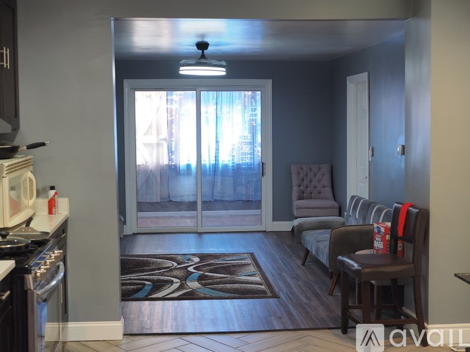 A kitchen with a stove top oven and a dining area with a table and chairs.