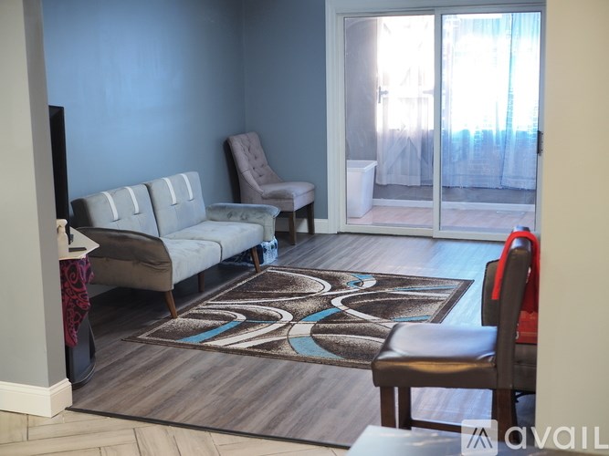 A living room with a sofa, chair, and rug.