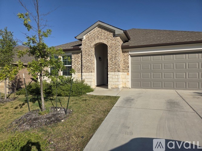 A house with a stone archway entrance and a garage door.