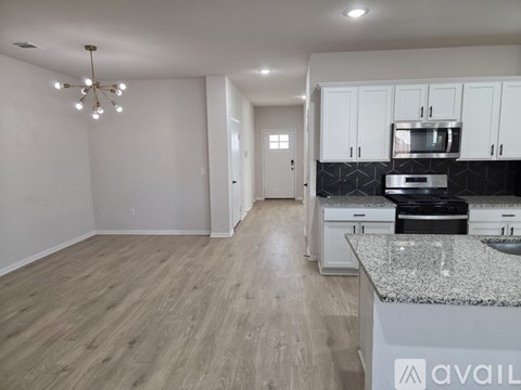 A kitchen with white cabinets and a granite countertop.