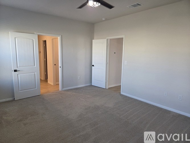 A room with a carpeted floor and a ceiling fan.