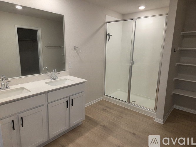 A bathroom with a sink, mirror, and shower.