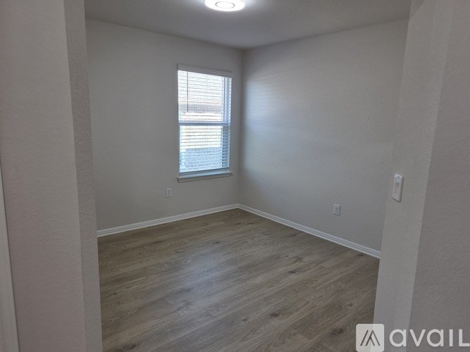 A room with wooden flooring and a window.