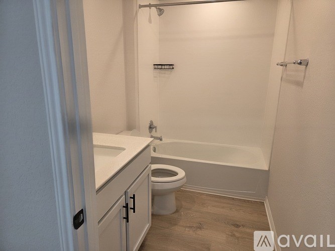 A white bathroom with a toilet, sink, and bathtub.