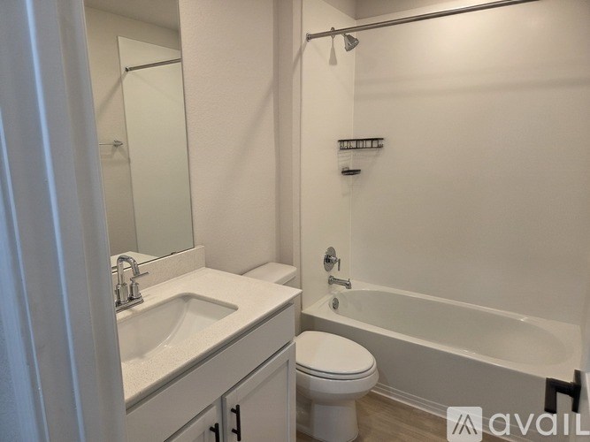 A white bathroom with a sink, toilet and bathtub.