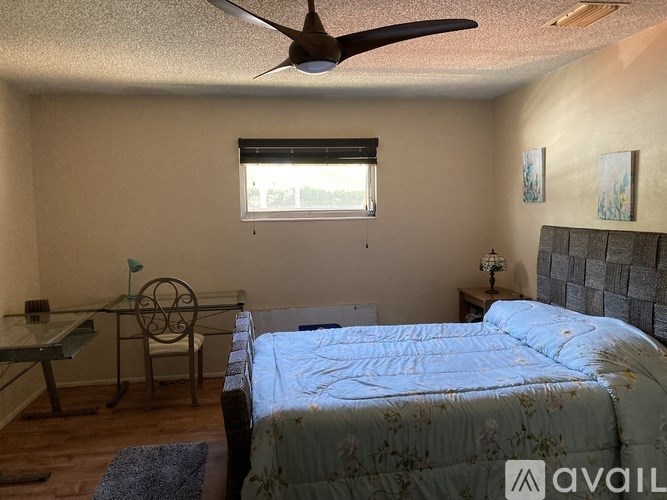 A bedroom with a bed, desk, and chair.