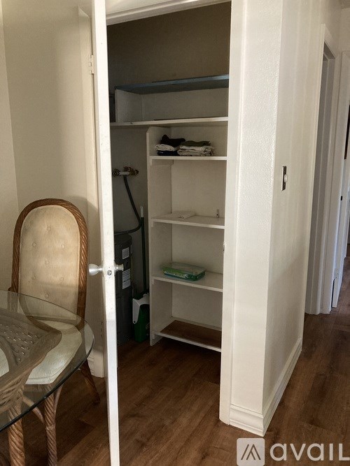 A small closet with a chair and a shelf.