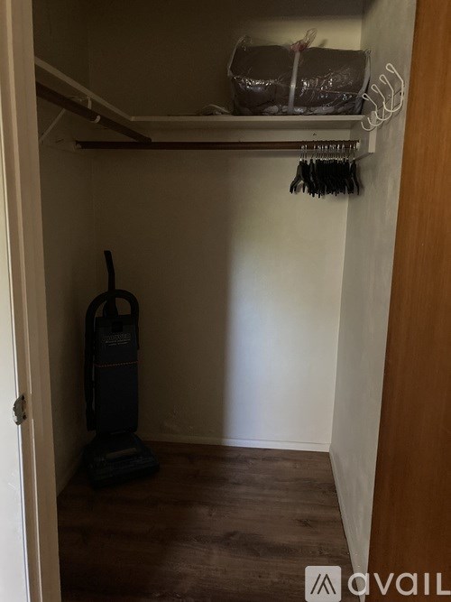 A vacuum cleaner is on the floor of a small room.