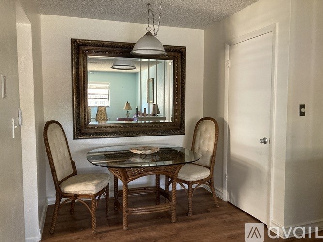 A dining room with a glass table and chairs.