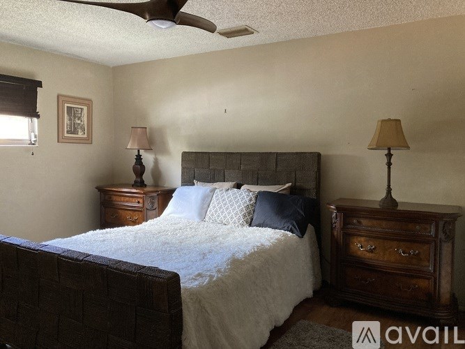 A living room with a glass coffee table and a red couch.