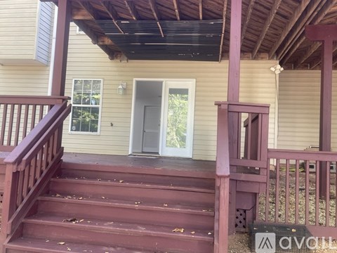 A house with a wooden porch and stairs leading to the front door.