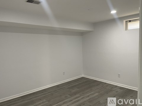 A room with wooden flooring and white walls.