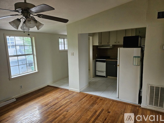 A room with a ceiling fan and wooden floors.