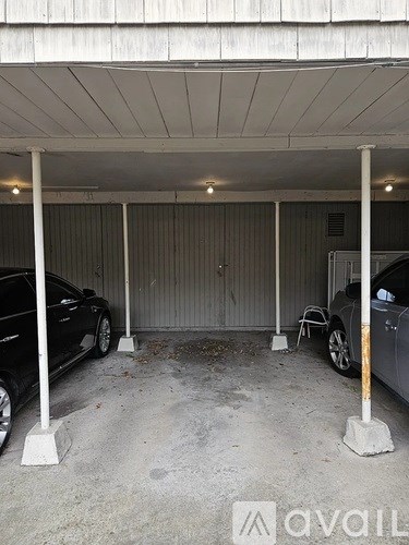 A car garage with two cars parked inside.