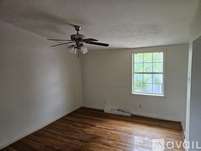 A room with a ceiling fan and a window.