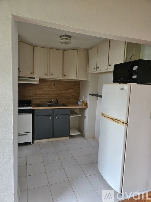 A kitchen with a white fridge and cabinets.