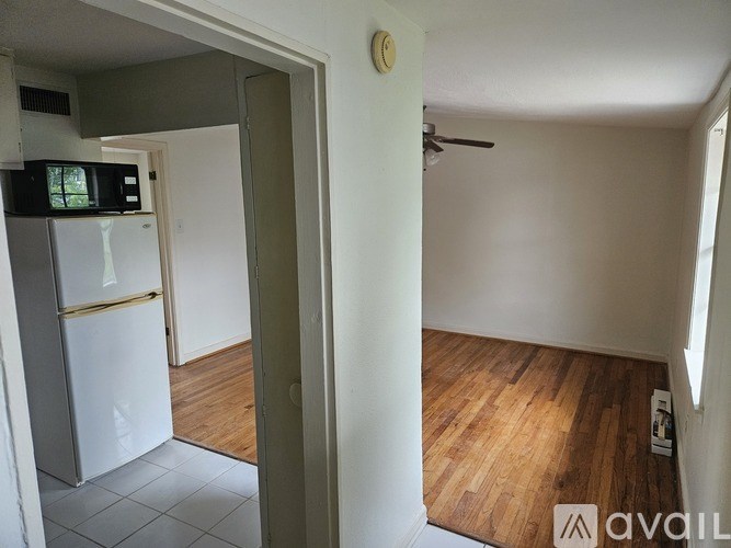 A kitchen with a white fridge and a white door.