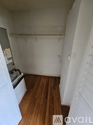 A small kitchen with white appliances and wood floors.