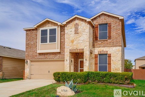 A house with a stone facade and a garage door is for sale.