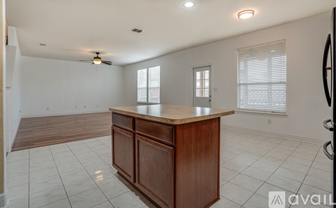 A spacious room with a wooden counter and a ceiling fan.