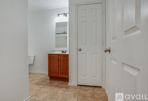 A bathroom with a white door and a brown cabinet.