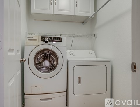 A white washing machine and dryer in a small laundry room.
