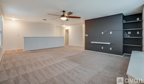 A spacious room with a ceiling fan and a large grey cabinet.