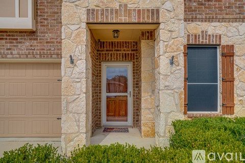 A house with a brown door and a window with wooden shutters.