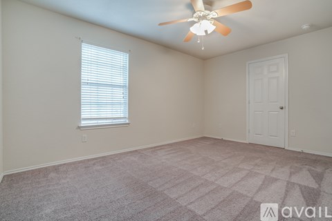 A room with a ceiling fan and a window with blinds.