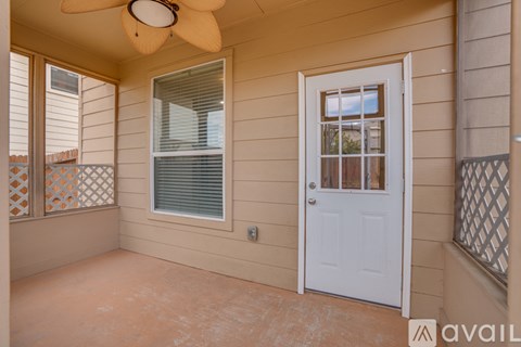 A room with a white door, a window with blinds, and a ceiling fan.