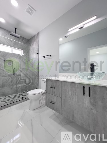 A bathroom with a toilet, sink, and shower.