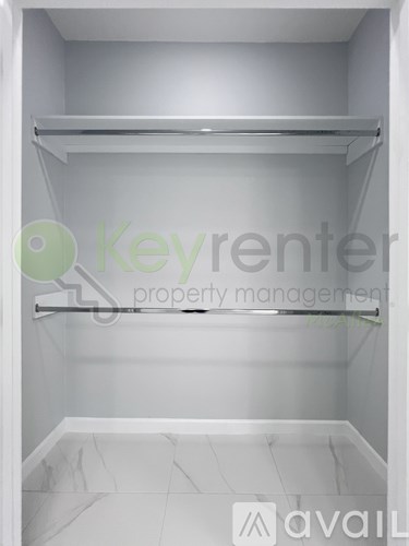 A white walk-in closet with shelves and a marble floor.