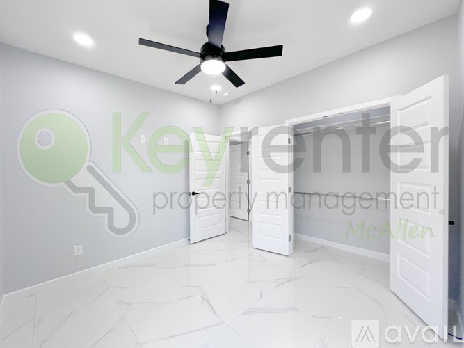 A room with a ceiling fan and a key logo on the wall.