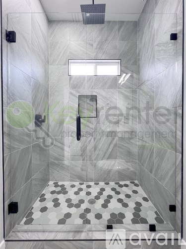 A bathroom with a tiled floor and walls.