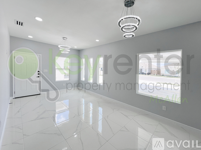 A spacious, well-lit room with a marble floor and a green door.