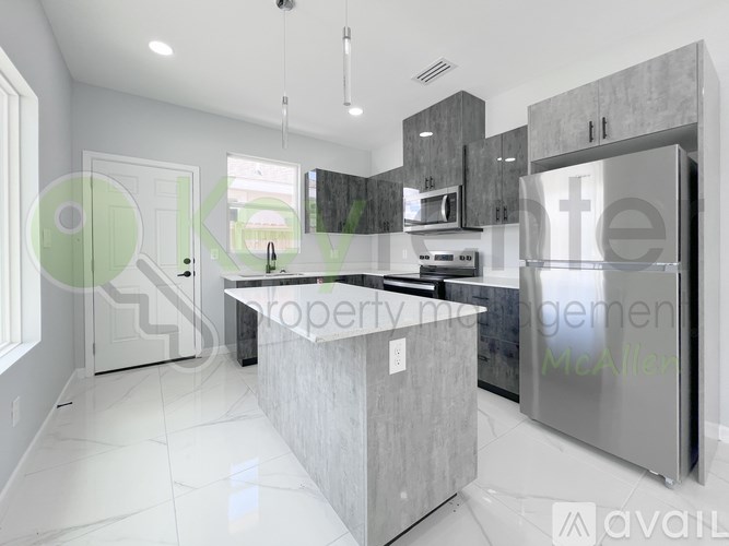 A modern kitchen with a central island and stainless steel appliances.