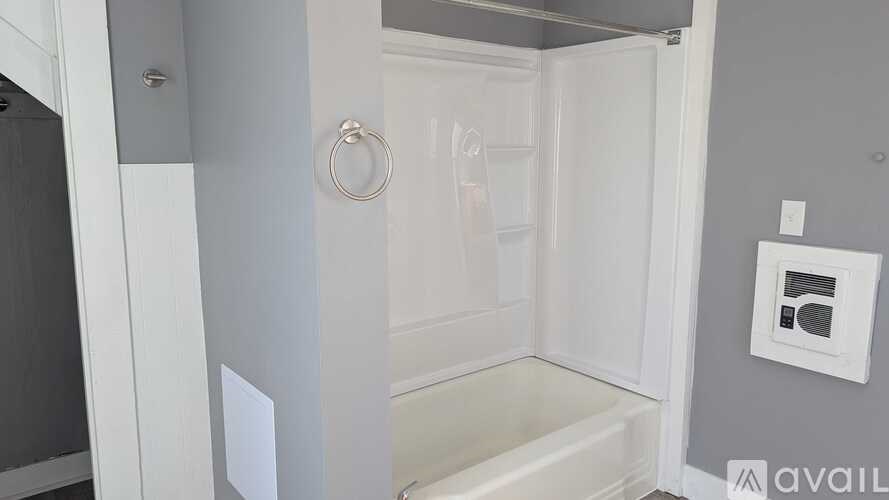 A small white bathroom with a toilet and a shower stall.