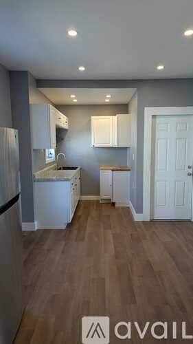 A kitchen with wooden floors and white cabinets.