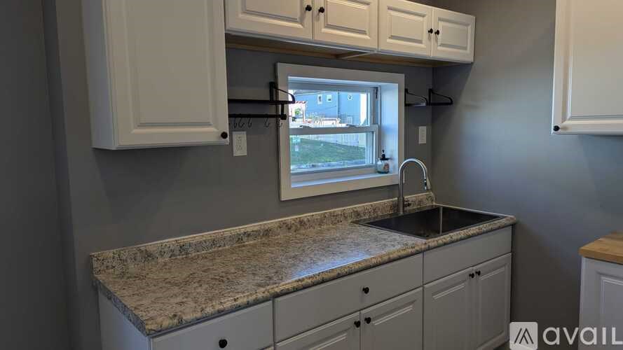 A kitchen with granite countertops and white cabinets.