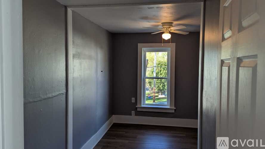 A room with a window and a ceiling fan.